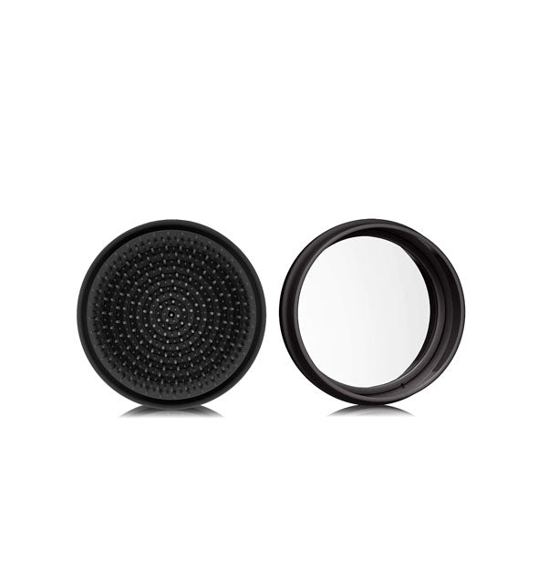 Round black macaron-shaped hairbrush shown open to reveal compact mirror inside