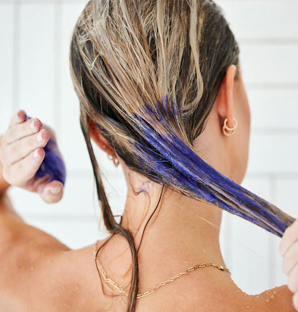 Model applies Unite Blonda Fix Violet Toning Treatment to the ends of wet hair