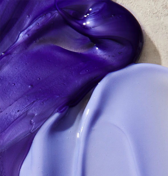 Closeup of dark and light purple shampoo and conditioner
