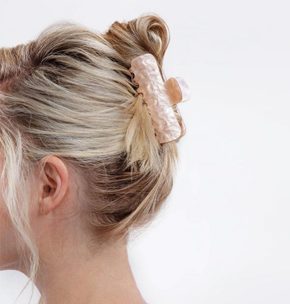 Model wears a hair clip with light-colored, marbled mother of pearl finish in an updo style