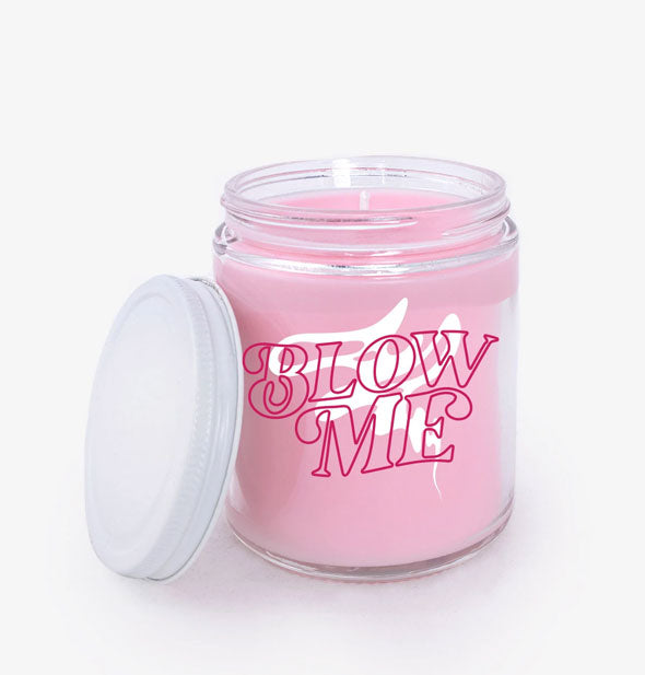 Pink candle in glass jar vessel with white lid to the siide sayys, "Blow Me" with white smoke graphic