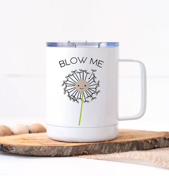 White travel mug with clear plastic lid features illustration of a smiling dandelion below the words, "Blow Me"