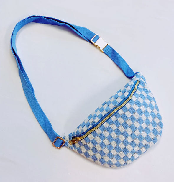 Blue and white checkered sling bag with blue strap and gold buckle and zipper hardware