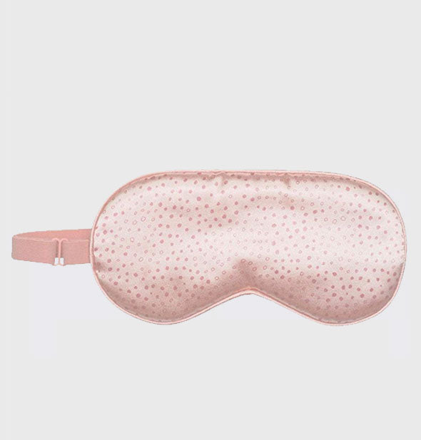Pink polkadot satin sleep mask with elastic band to the left