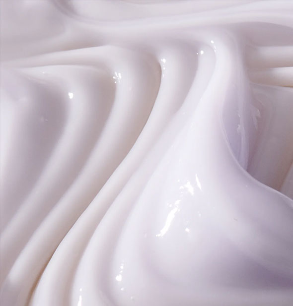 Closeup of white hair cream with ridges combed through it