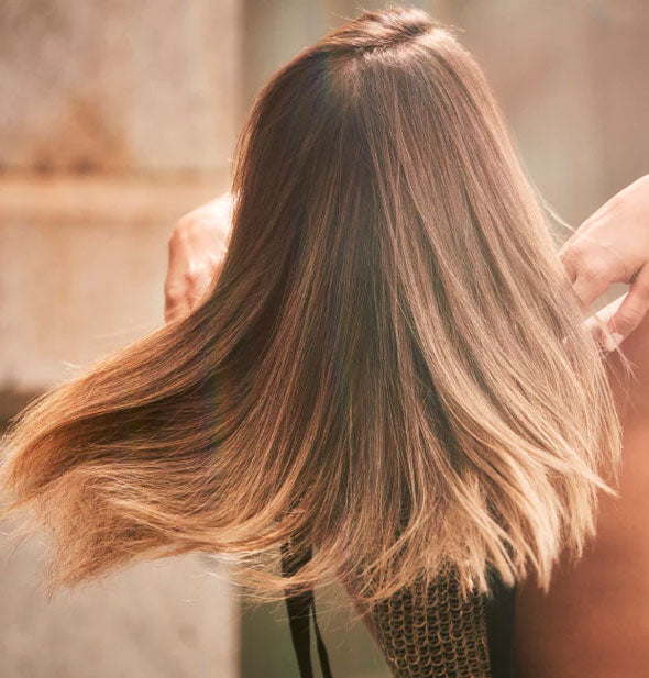 Model flips hair to show results of using Bumble and bumble Bond-Building Repair Shampoo