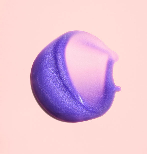 Sample dab of Oribe Bright Blonde Essential Priming Serum shows product's purple pigmentation and slight iridescence