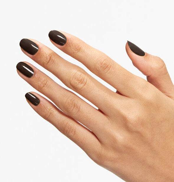 Model's hand wears a dark brown shade of nail polish