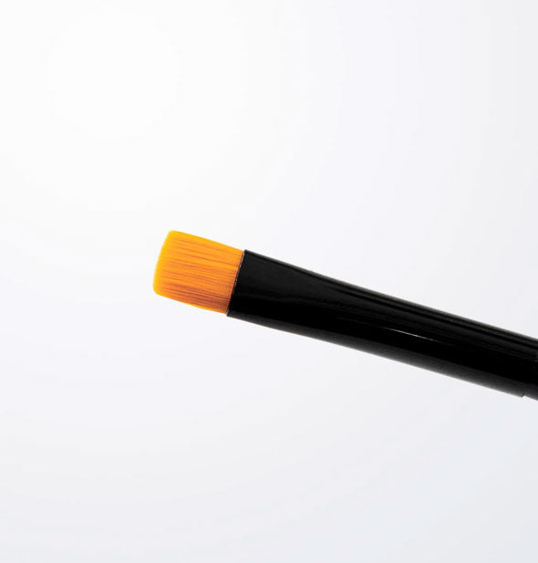 Makeup brush with short, stiff yellow bristles