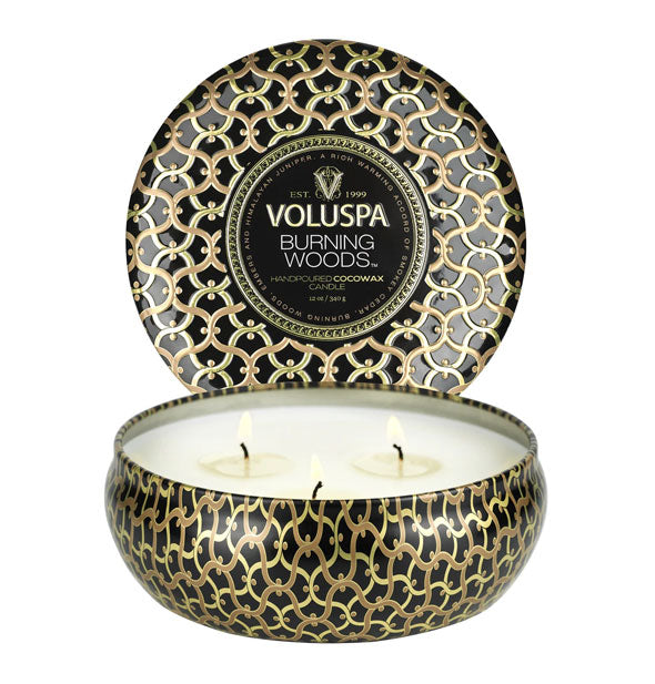 Decorative Voluspa Burning Woods candle tin with intricate pattern and three burning wicks