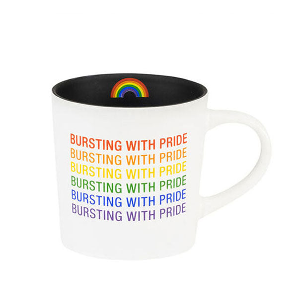 White coffee mug with black interior that features a rainbow graphic says, "Bursting with pride" repeated six times in rainbow colors