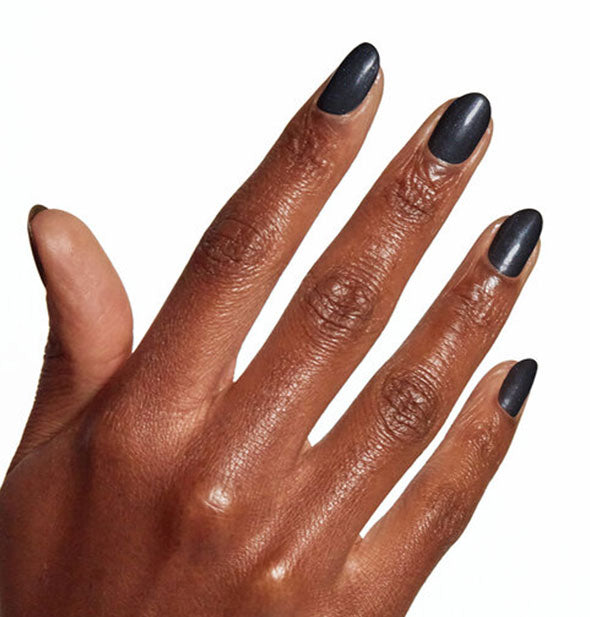 Model's hand wears a slightly pearlescent shade of black nail polish