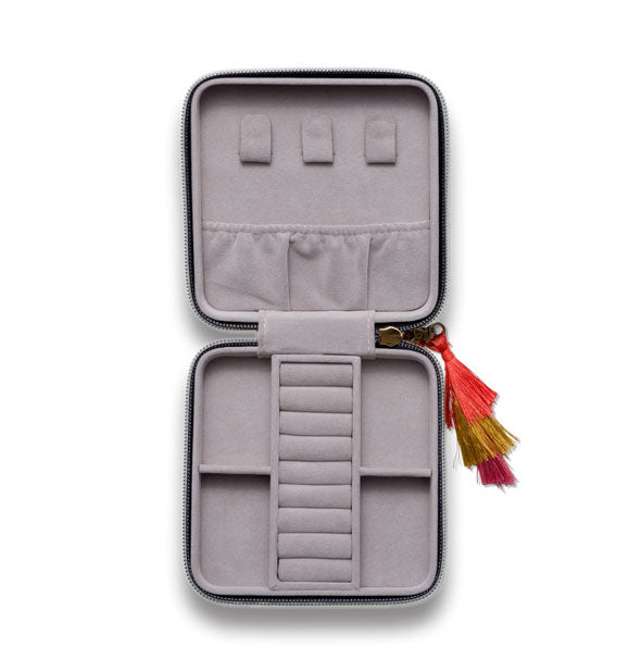 Open square case with gray interior has various slots and sections for jewelry storage; a colorful tassel zipper pull extends out to the side