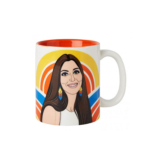White coffee mug with red interior features illustration of 70s-era Cher wearing colorful earrings in front of bold color arcs