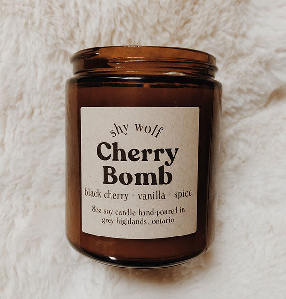Amber glass jar Cherry Bomb candle on white fur background
