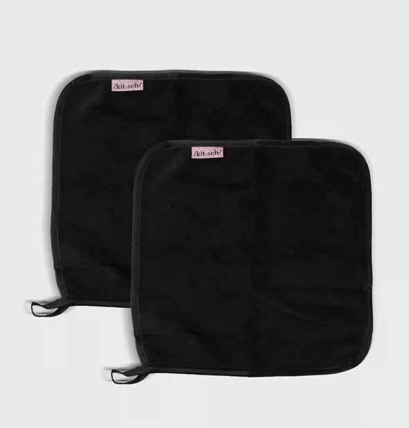 Two squarish black towels with hanging loops and pink Kitsch labels