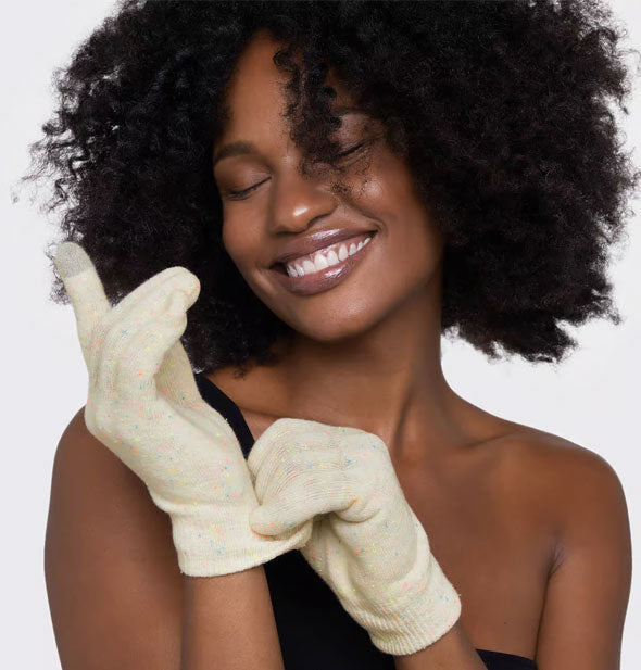 Smiling model wears a pair of Kitsch Moisturizing Spa Gloves