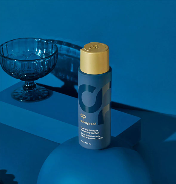 ColorProof Clear It Up Shampoo is staged on a blue background with other blue items