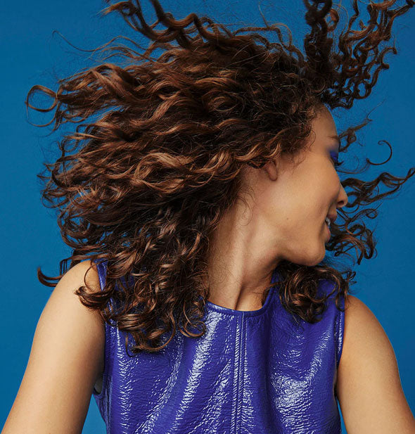 Model swings curly, healthy-looking shoulder-length hair