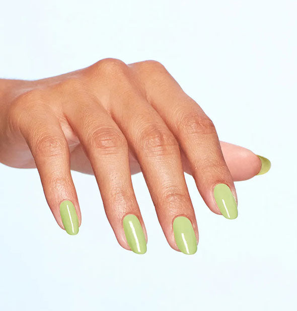Model's hand wears a light shade of green nail polish