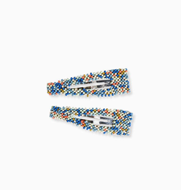 Pair of beaded snap-style hair clips with predominantly blue shades along with orange, yellow, and white accents