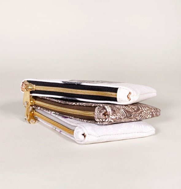 Stack of three pouches with gold zipper hardware shown