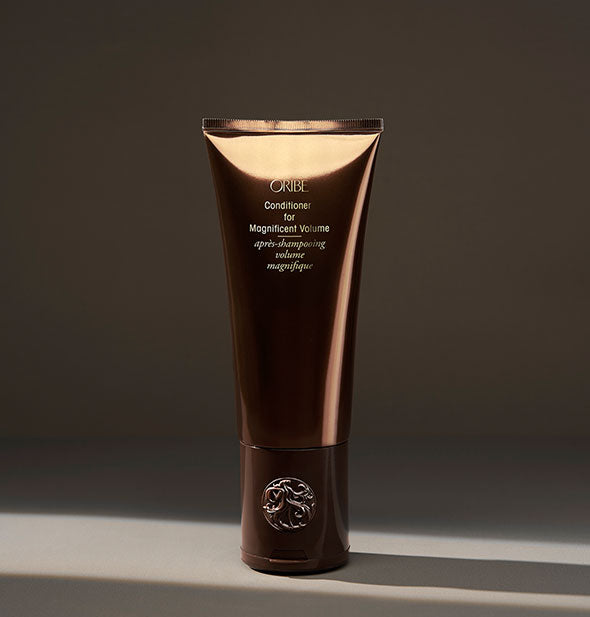 Brown bottle of Oribe Conditioner for Magnificent Volume on dark background