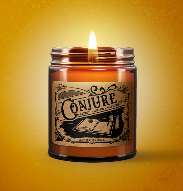 Lit Conjure candle on yellow backdrop