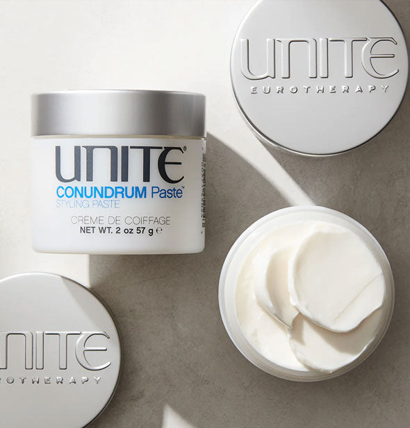 Jars of Unite CONUNDRUM Paste, one of which is opened to show creamy white product inside from the top