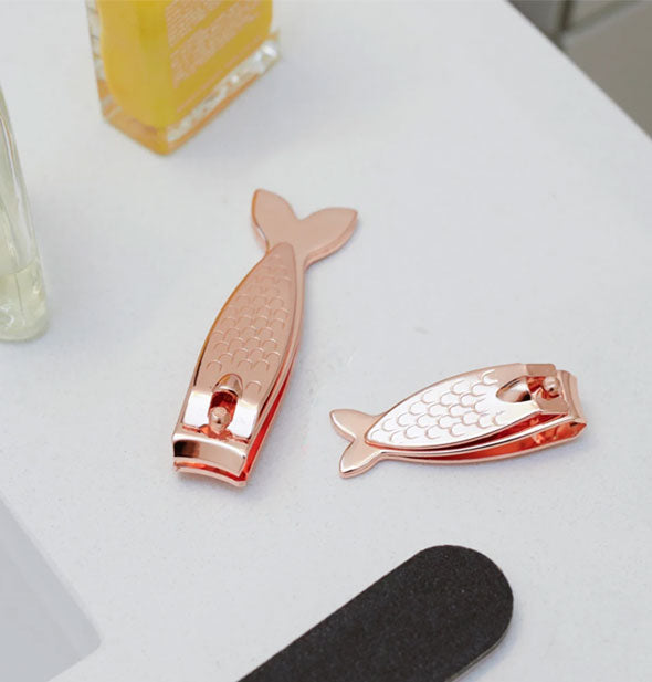 One large and one small fish-shaped copper toenail clipper