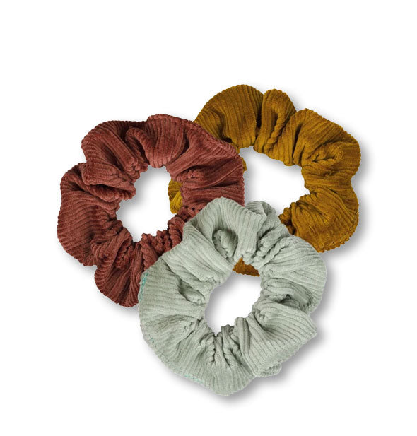 Three corduroy hair scrunchies in dark brown, light brown, and gray