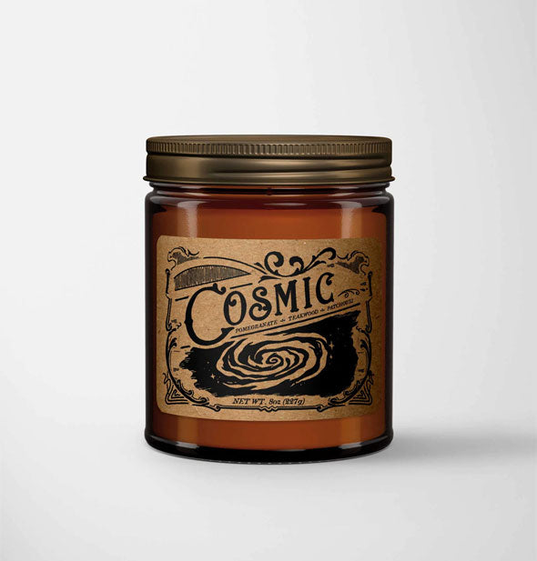 Cosmic candle in amber glass jar with metal lid features a kraft paper label in a vintage style with galaxy illustration