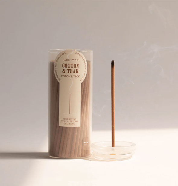 Lid removed from a glass tube of Paddywax Cotton & Teak incense sticks doubles as a holder for one burning stick