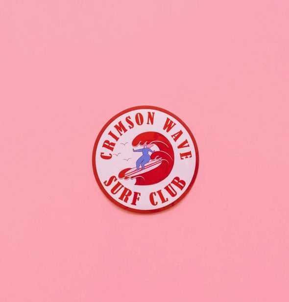 Round sticker with surfer graphic says, "Crimson Wave Surf Club"