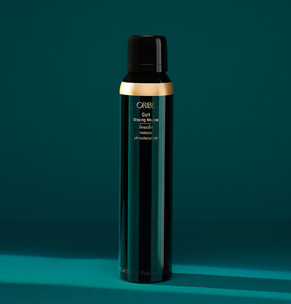 Dark teal and gold can of Oribe Curl Shaping Mousse with gold accent on dark teal background