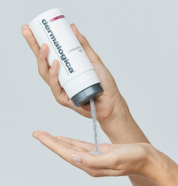 Model pours Dermalogica AGE Smart Daily Superfoliant powder from bottle into hand