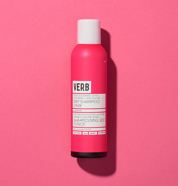 Dark pink, white, and black can of Verb Dry Shampoo Dark rests on a pink backdrop