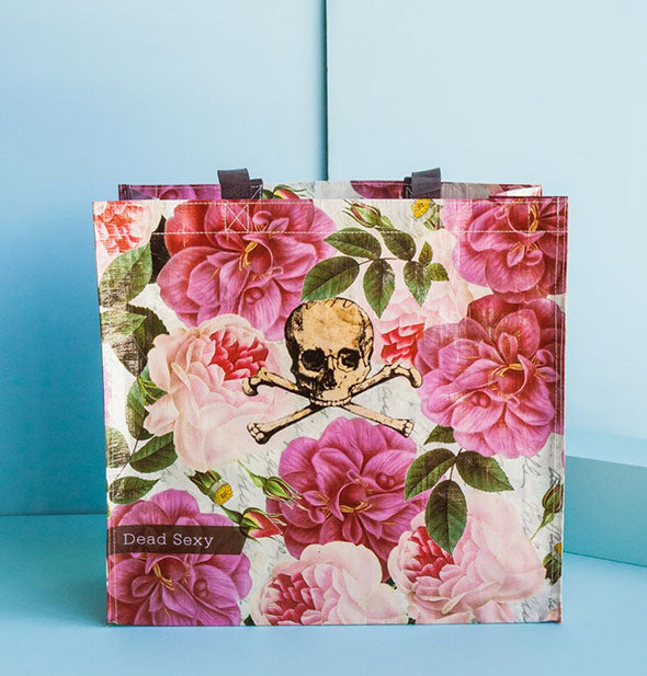 Rectangular tote bag with all-over pink peonies design says "Dead Sexy" in the bottom left corner and features a skull and crossbones illustration in the center