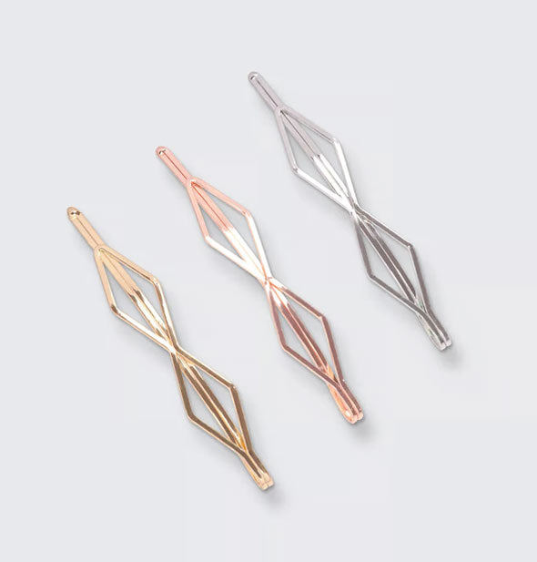 Three diamond-shaped bobby pins, one gold, one rose gold, and one silver