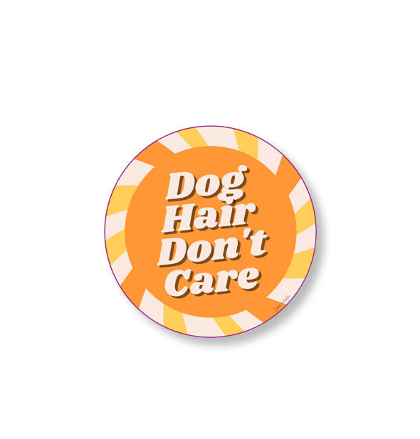 Round sticker with yellow and orange striped outline around an orange center says, "Dog Hair Don't Care" in white lettering