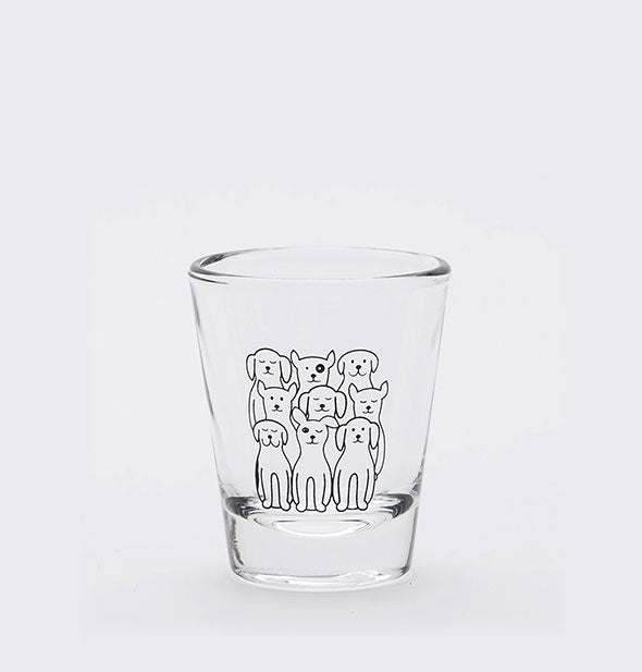Clear shot glass is printed with black outline drawing of nine dogs, each different.