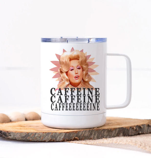 White travel mug with clear lid and squared handle features image of Dolly Parton mid-song with the words, "Caffeine, caffeine, caffeeeeeeeine" underneath