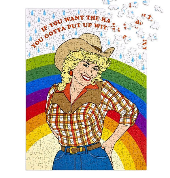 Rectangular jigsaw puzzle with portrait of smiling Dolly Parton in cowgirl outfit with rainbow behind says, "If you want the rainbow you gotta put up with the rain"