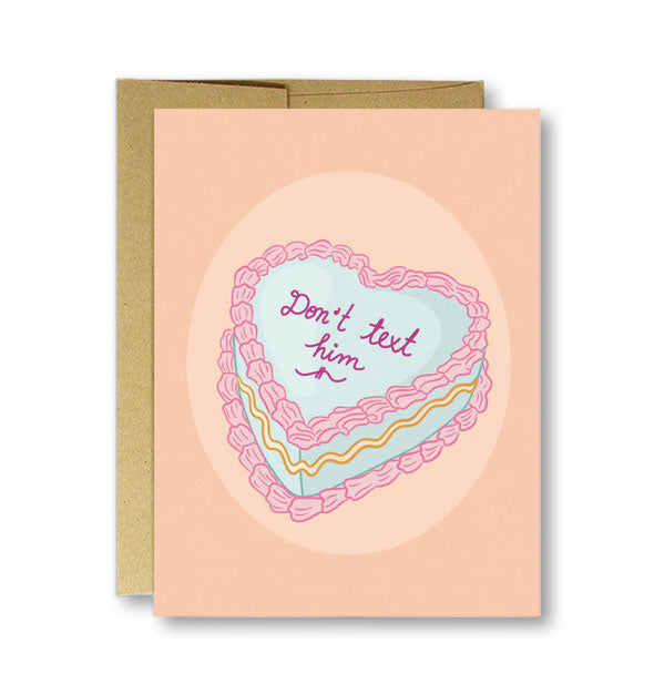 Peach-colored greeting card on top of kraft envelope features illustration of a heart-shaped cake with icing that says, "Don't text him"