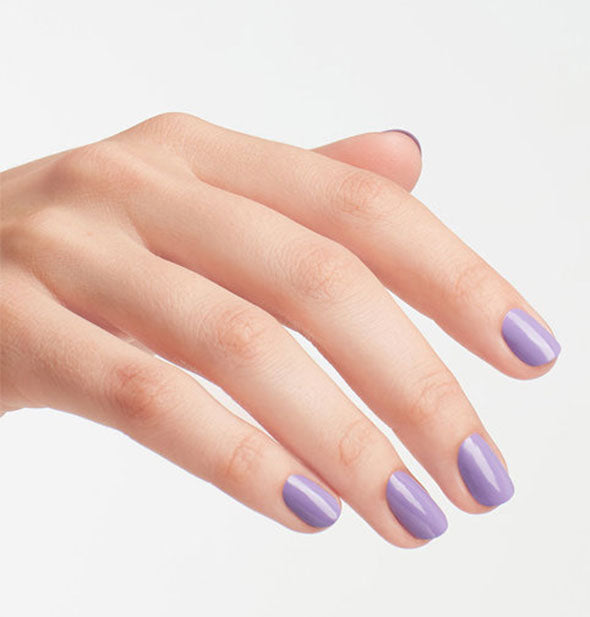 Model's hand wears a shade of purple nail polish