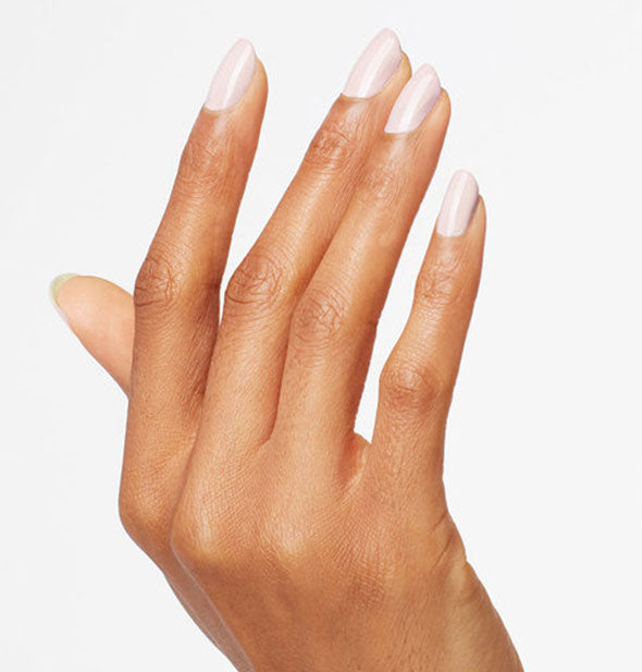 Model's hand wears a light gray-pink shade of nail polish