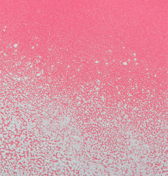 Powder application of dry shampoo on a pink surface