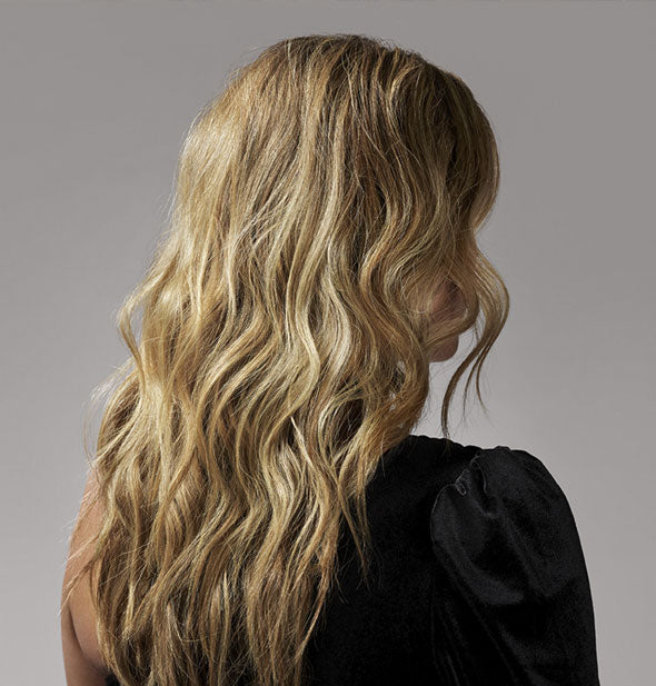 Long, blonde, loosely wavy hair that has been styled with Oribe Dry Texturizing Spray