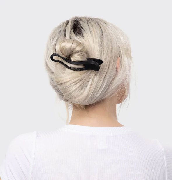 Model wears a matte black slender hair clip in a twisted updo