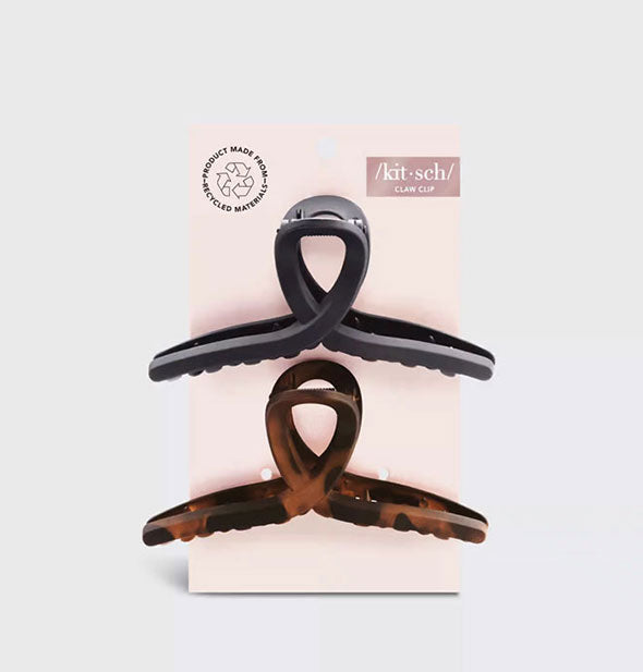 Two loop shape recycled material claw clips, one black and one brown tortoise, on light pink Kitsch blister card